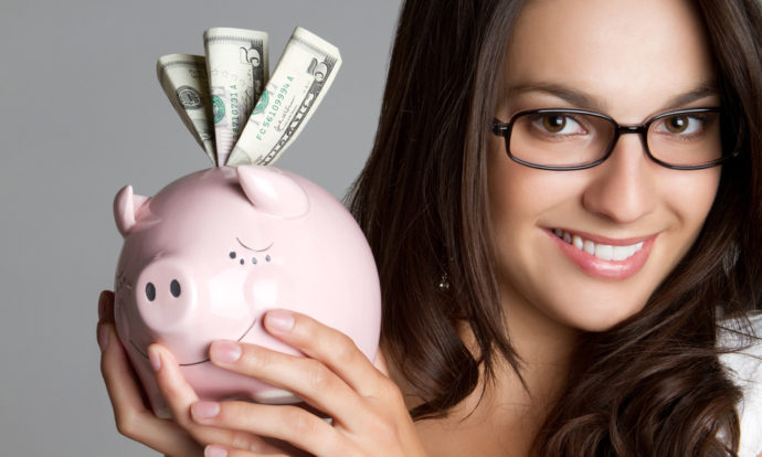 Smiling woman holding piggy bank money