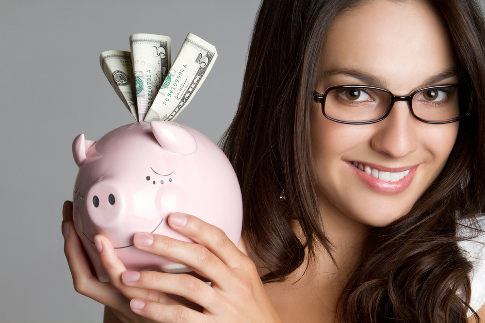 Smiling woman holding piggy bank money